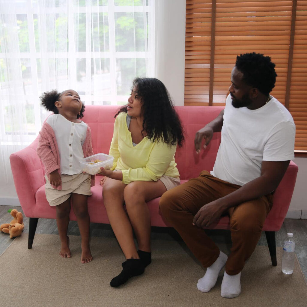 family sitting on a couch playing